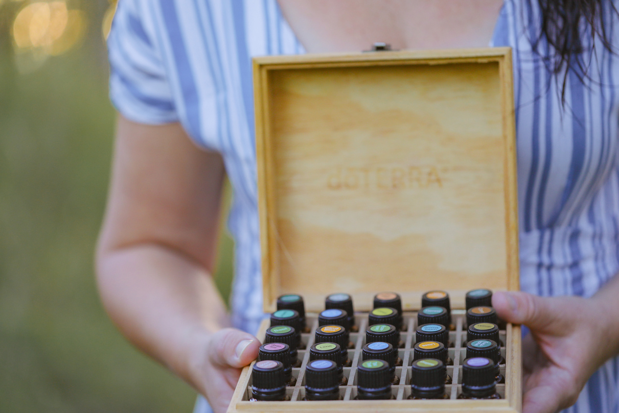 Firefly NSW Australia - 20 April 2022: Woman Standing in Field Holding Wooden Storage Box Full of Doterra Essential Oils
